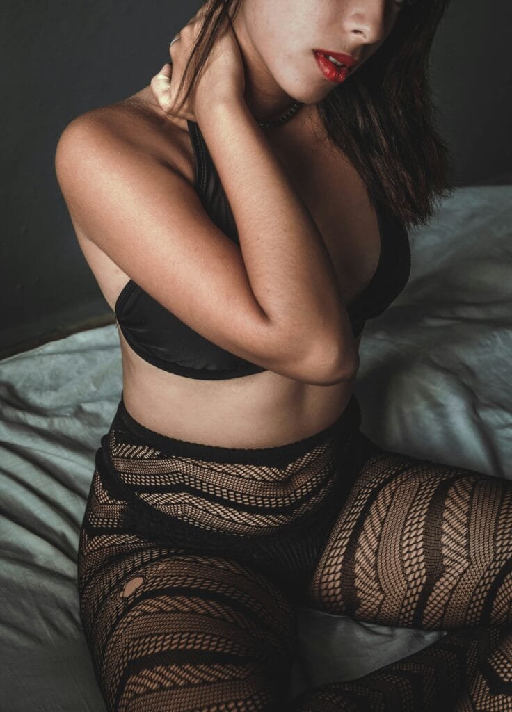 Luxury escort in a classic black dress smiling warmly, showcasing her professional charm.